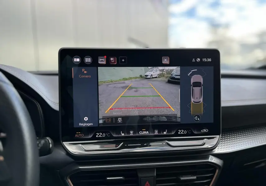 Écran tactile central affichant la caméra de recul d'un CUPRA Formentor blanc Neige, intérieur moderne avec tableau de bord noir.