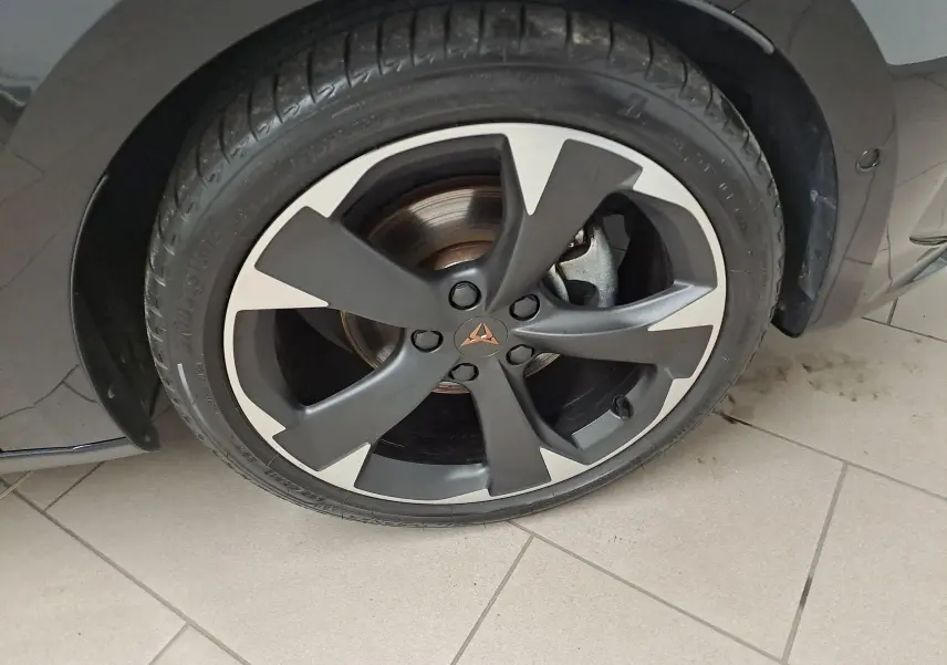 Gros plan sur la roue avant droite de la CUPRA Leon 2023 noir minuit, mettant en valeur la jante noire et argentée au design distinctif.