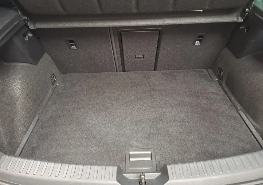 Coffre ouvert de la CUPRA Leon 2023 noir minuit, vue intérieure montrant l'espace de chargement et les fixations.