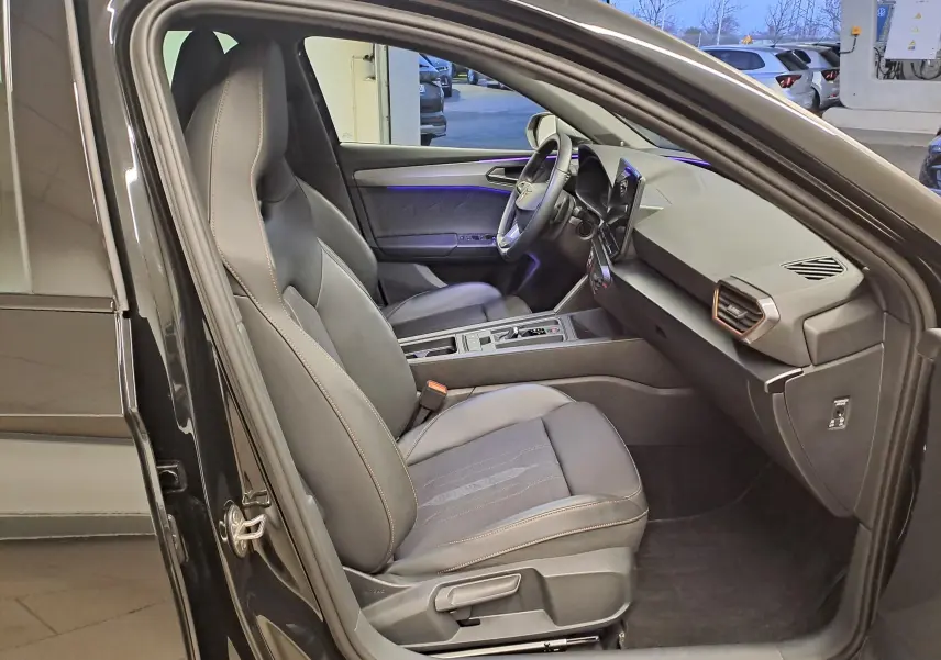 Intérieur côté conducteur de la CUPRA Leon 2023 noir minuit, avec sièges sport et tableau de bord moderne.