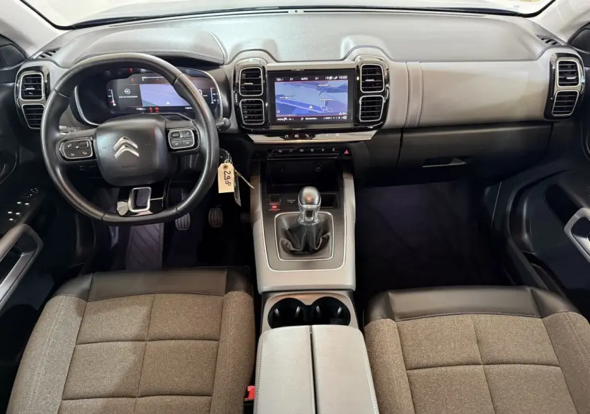 Vue intérieure avant du Citroën C5 Aircross bleu, montrant le volant cuir multifonctions et l’écran tactile central.