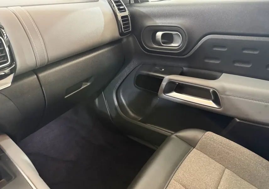 Intérieur côté passager du Citroën C5 Aircross 2021, montrant la porte et le tableau de bord en noir et beige.