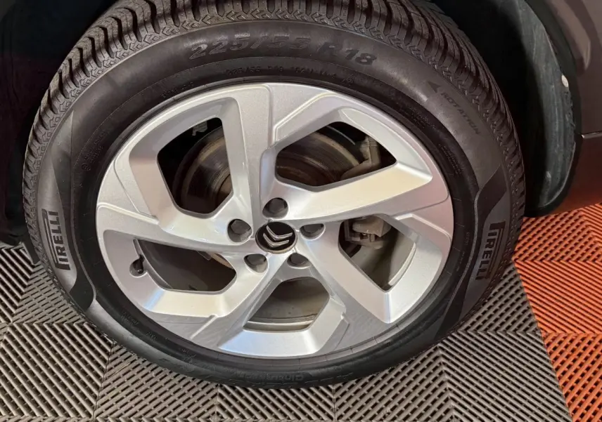 Gros plan sur la roue avant gauche avec jante argentée et pneu Pirelli du Citroën C5 Aircross bleu.