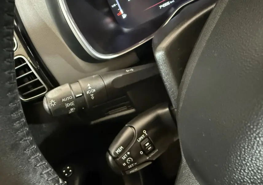 Gros plan sur le volant cuir et les commandes du régulateur de vitesse du Citroën C5 Aircross bleu, intérieur avant.