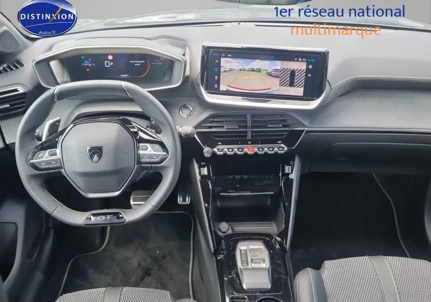 Vue intérieure frontale du tableau de bord et volant cuir noir de la Peugeot 208 gris, avec écran tactile affichant la caméra 360°.