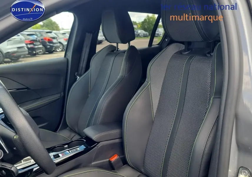 Vue intérieure côté conducteur des sièges sport en tissu et cuir gris avec surpiqûres vertes d'une Peugeot 208 1.2 hybrid 136 GT.