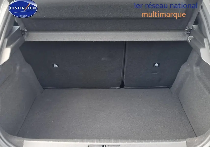 Coffre ouvert vu de face d'une Peugeot 208 gris, montrant l'espace de chargement et la banquette arrière rabattable.