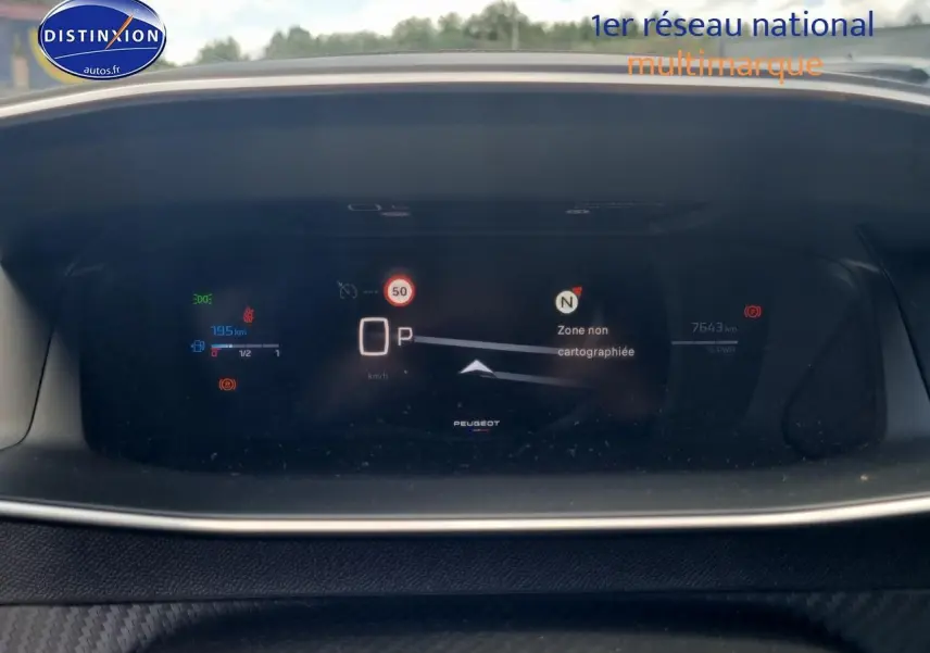 Tableau de bord numérique de Peugeot 208 gris 2025 affichant vitesse, autonomie et navigation en mode parking.