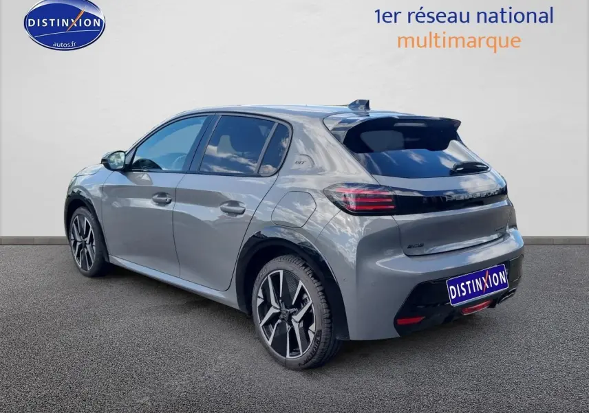 Peugeot 208 gris vue 3/4 arrière droit, jantes alu 17 pouces et toit noir avec badge GT visible.