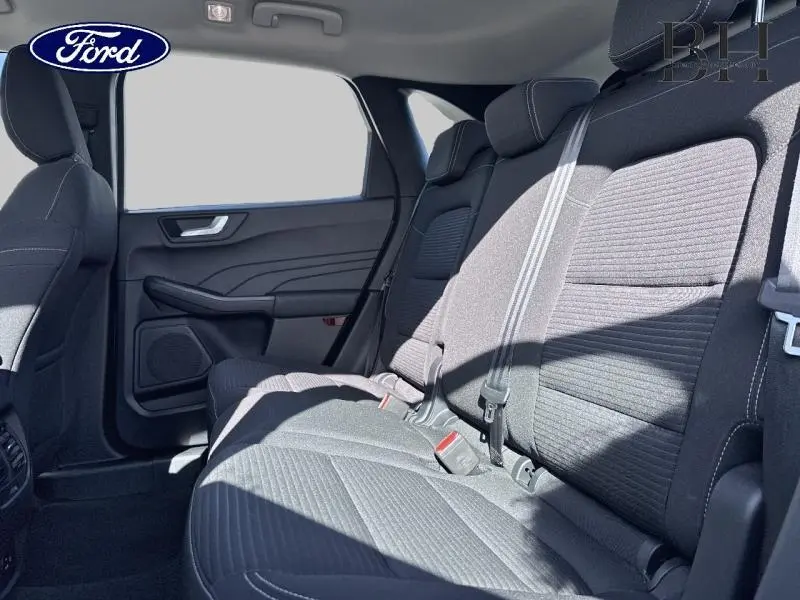 Vue intérieure arrière du Ford Kuga 2022, sièges tissu noir Ray/Eton avec ceintures et appuie-têtes visibles.