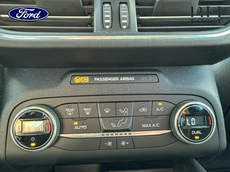 Tableau de bord du Ford Kuga 2022 gris, montrant les commandes de climatisation automatique bi-zone et l'airbag passager activé.