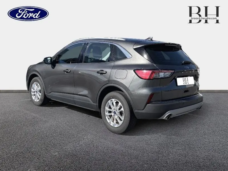 Ford Kuga gris métallisé vu en 3/4 arrière droit, soulignant ses lignes modernes et ses jantes alu.
