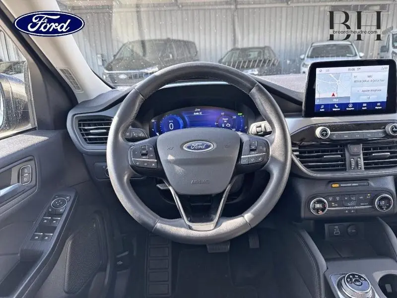 Vue intérieure centrée sur le volant cuir multifonction du Ford Kuga 2022 avec écran tactile et tableau de bord numérique.