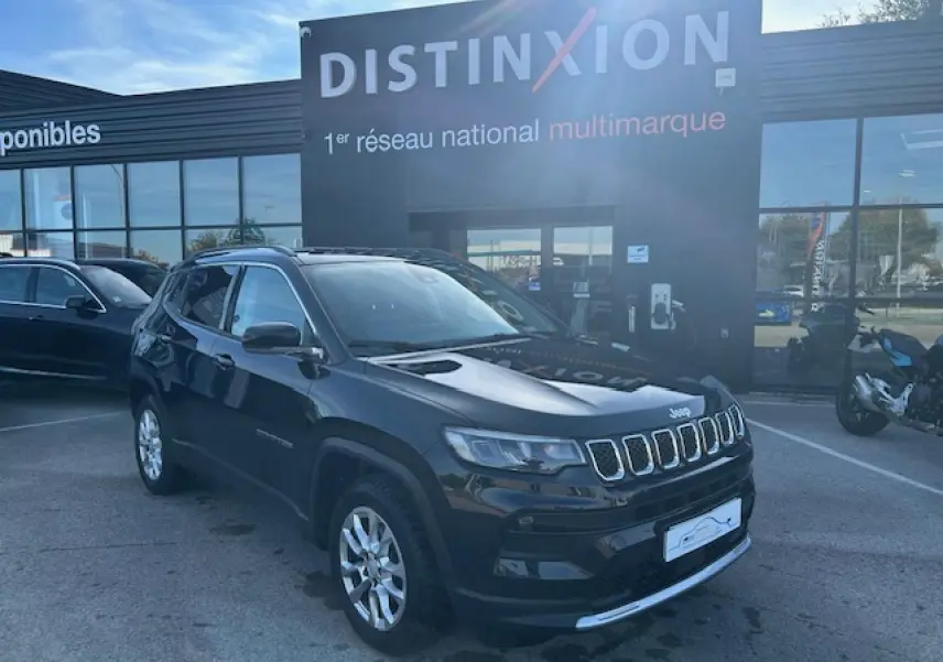 Jeep Compass noir métallisé en 3/4 avant droit, avec calandre à sept fentes et jantes alliage 17 pouces visibles.