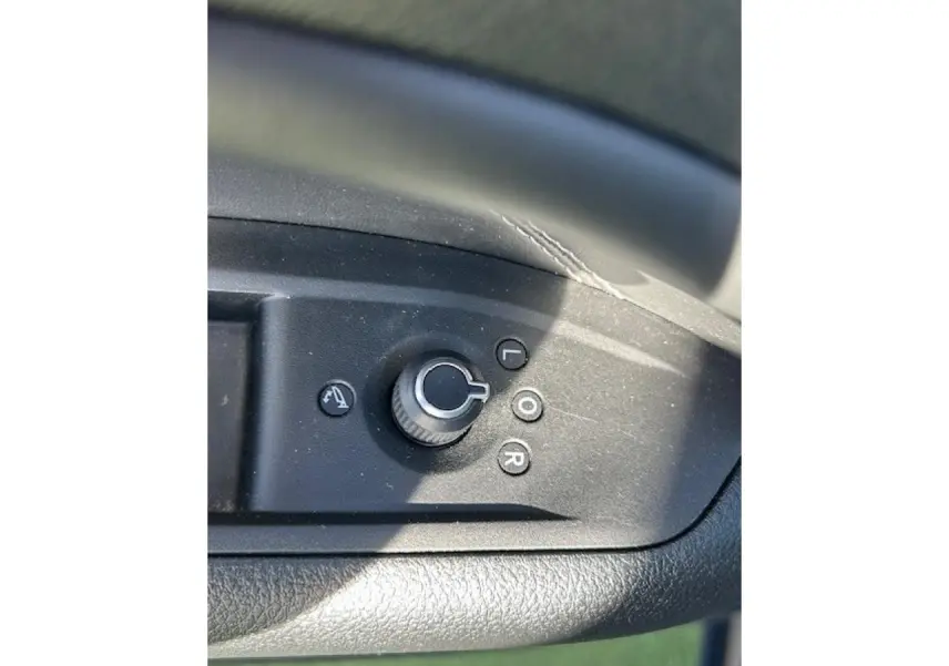 Gros plan sur la commande de réglage des rétroviseurs côté conducteur du Jeep Compass noir 2021.