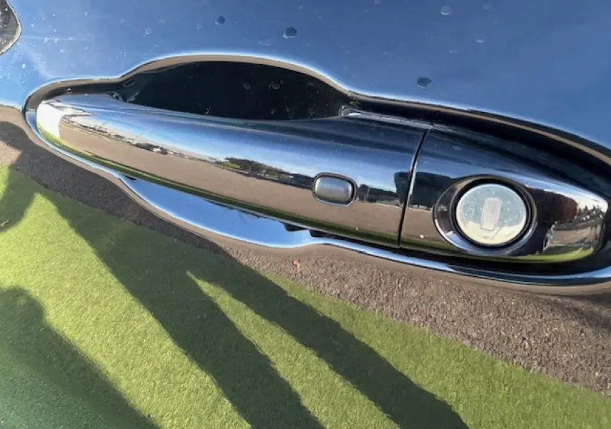 Poignée de porte noire brillante côté gauche du Jeep Compass 2021 avec serrure intégrée et reflet extérieur.