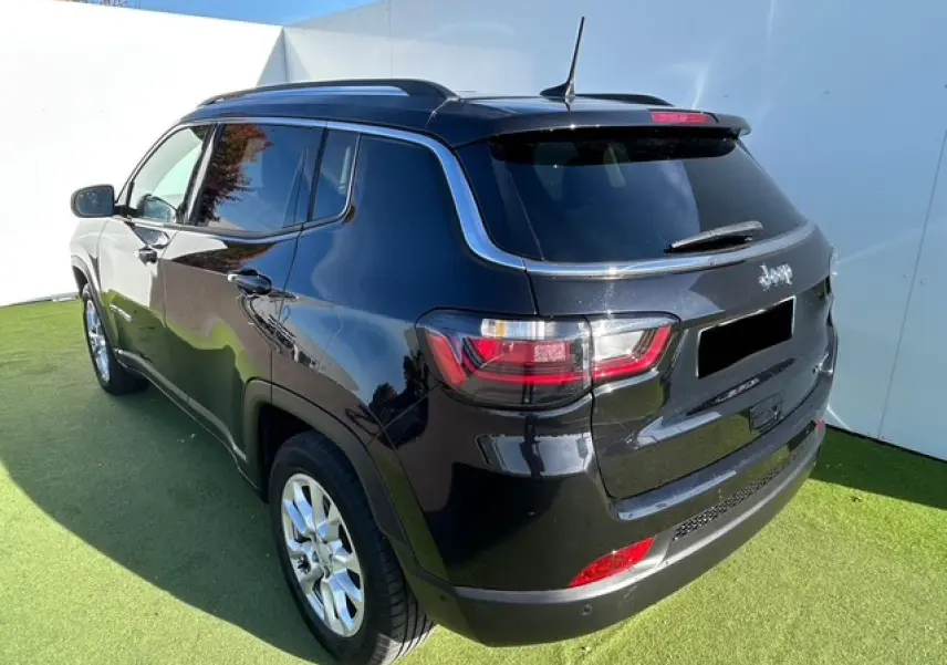 Vue 3/4 arrière droite du Jeep Compass noir métallisé avec barres de toit et feux arrière LED distinctifs