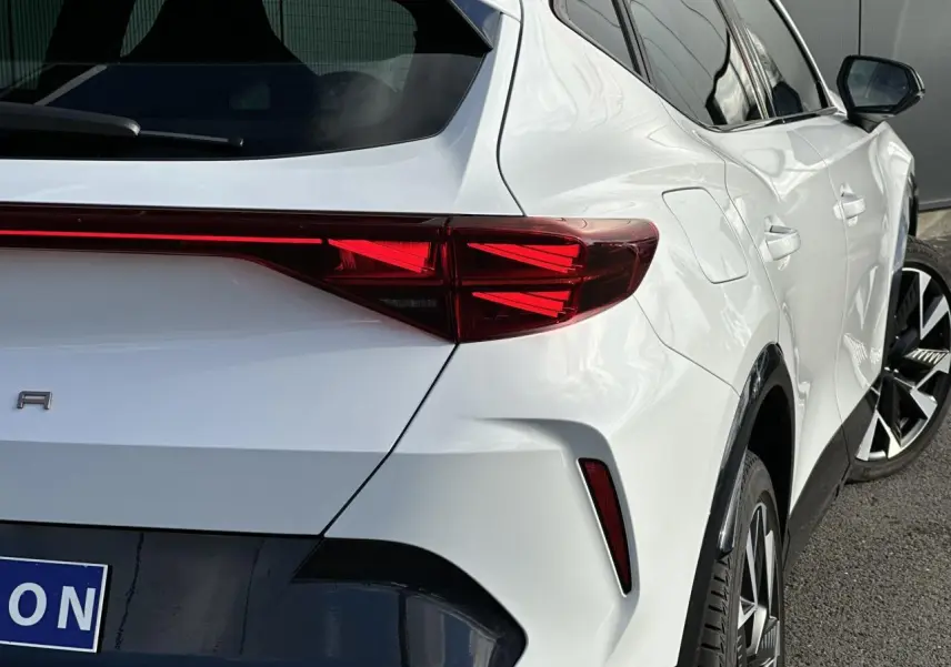 Vue 3/4 arrière droite d'une CUPRA Formentor blanc Neige avec feux arrière Tri-LED et jantes alliage 19'' Sandstorm.