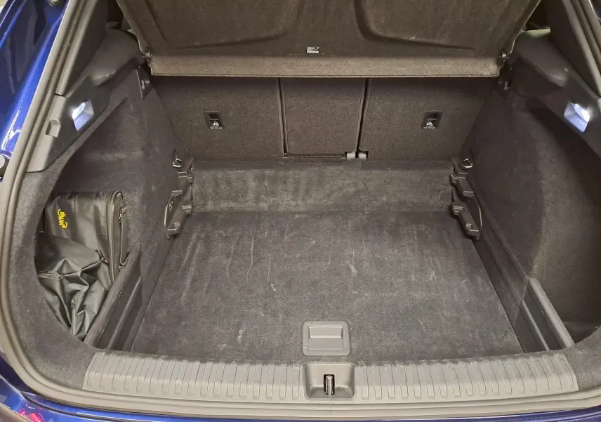 Coffre ouvert vu de l'arrière d'une CUPRA TERRAMAR Bleu Cosmos, montrant un espace de chargement propre et bien fini.