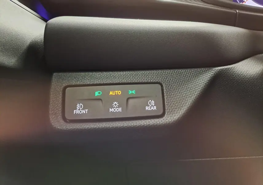Détail du tableau de bord avec commandes d'éclairage activées sur mode auto, intérieur noir du CUPRA Terramar 2025.