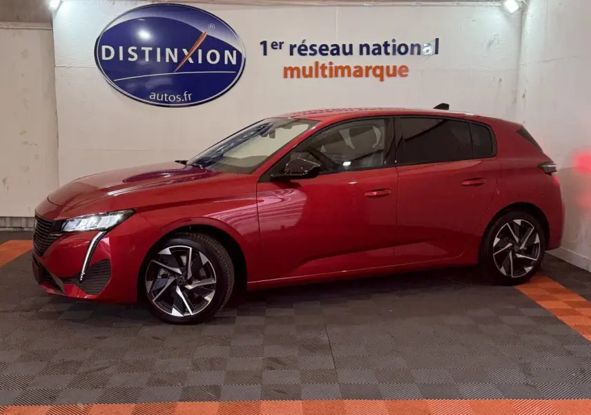 Peugeot 308 BlueHDi 130 AUTO8 Allure rouge vue de profil côté gauche dans un garage avec logo Distinxion en arrière-plan.
