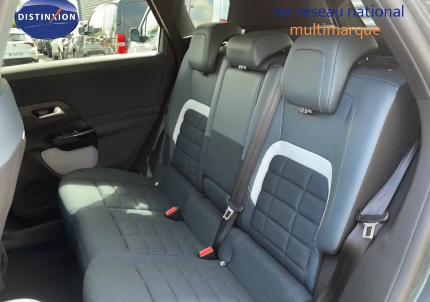 Vue intérieure sur la banquette arrière du Citroën C5 Aircross Hybrid avec sièges tissu et cuir noir, ceintures visibles.