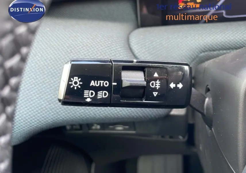 Gros plan sur la commande des feux et clignotants du Citroën C5 Aircross Hybrid, intérieur tissu gris.