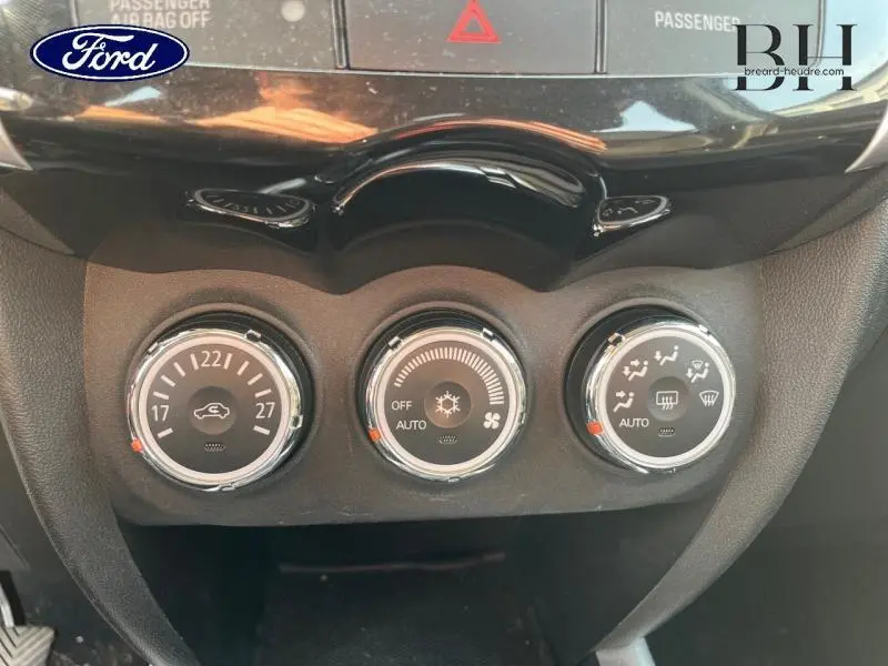 Gros plan sur les commandes de climatisation du tableau de bord d'une Citroën C4 Aircross brun Mangaro, version 2016.