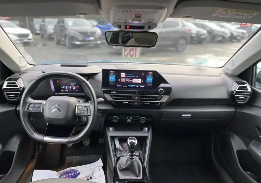 Vue intérieure avant du tableau de bord et volant d'une Citroën C4 2021 avec écran tactile et boîte manuelle.