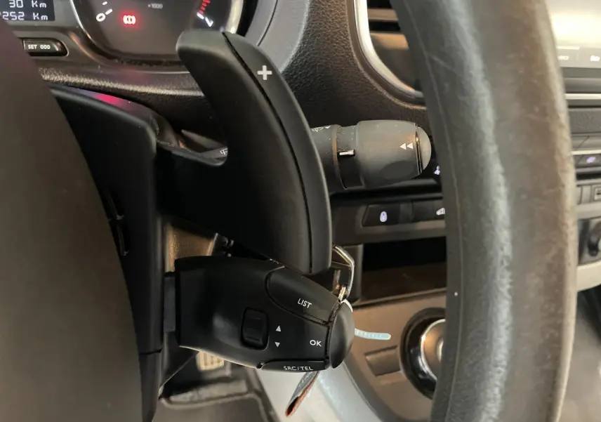 Gros plan sur le volant et commandes au volant du fourgon blanc Opel Vivaro 2021, avec palettes de changement de vitesse.