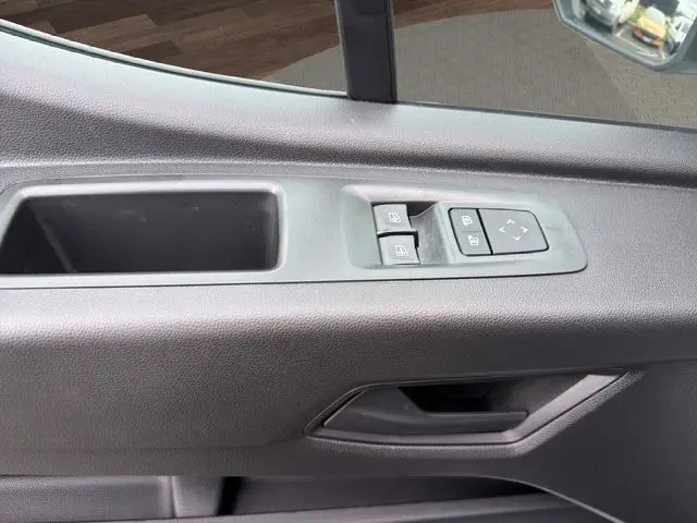 Gros plan sur la porte intérieure côté conducteur du Renault Master blanc, montrant les commandes des vitres et des rétroviseurs.