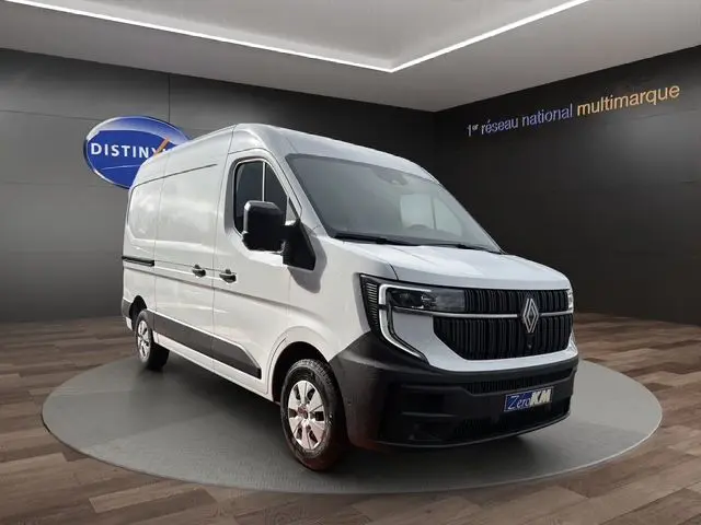 Vue 3/4 avant d’un Renault Master blanc avec calandre noire et jantes argentées dans un showroom.