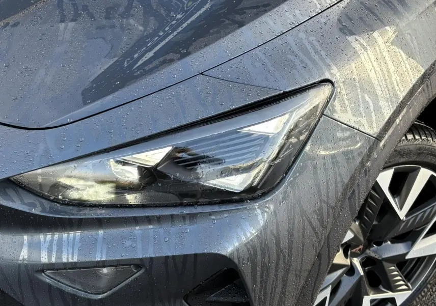 Gros plan sur l'avant droit blanc du CUPRA Formentor 2025, mettant en valeur son phare LED et la jante alliage distinctive.