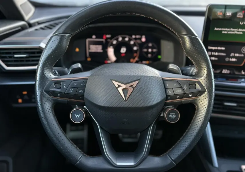 Intérieur du CUPRA Formentor 2025, vue rapprochée du volant cuir noir avec logo cuivre et tableau de bord digital.