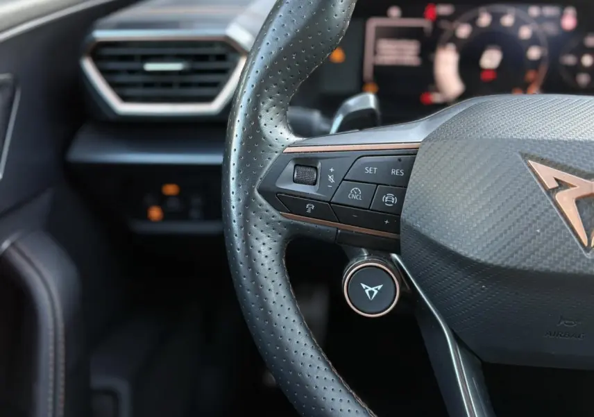 Gros plan sur les commandes électriques du siège conducteur en suédine noir asphalte du CUPRA Formentor gris magnétique.