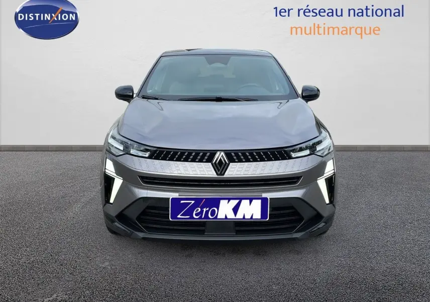 Vue frontale d'un Renault Captur E-Tech hybride gris Cassiopée avec toit noir, feux LED allumés sur fond neutre.