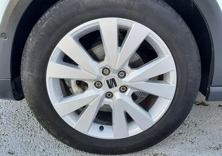 Gros plan sur la jante alliage argentée avec logo SEAT d’un SEAT Arona 2025 blanc Nevada toit gris.