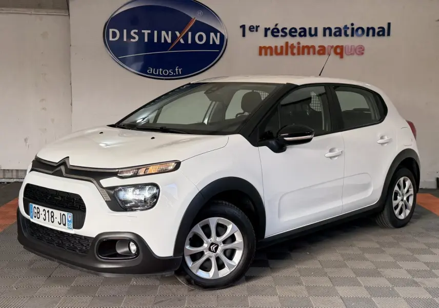 Vue 3/4 avant droite d'une Citroën C3 blanche 2021 avec phares LED et rétroviseurs noirs brillants.