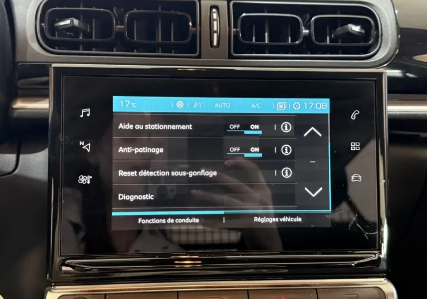 Écran tactile central de la Citroën C3 blanche, vue rapprochée du tableau de bord avec commandes activées.