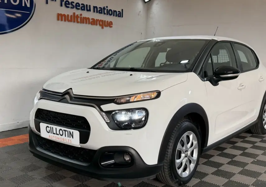 Citroën C3 blanche vue 3/4 avant droit, avec phares LED allumés et jantes alliage argentées.