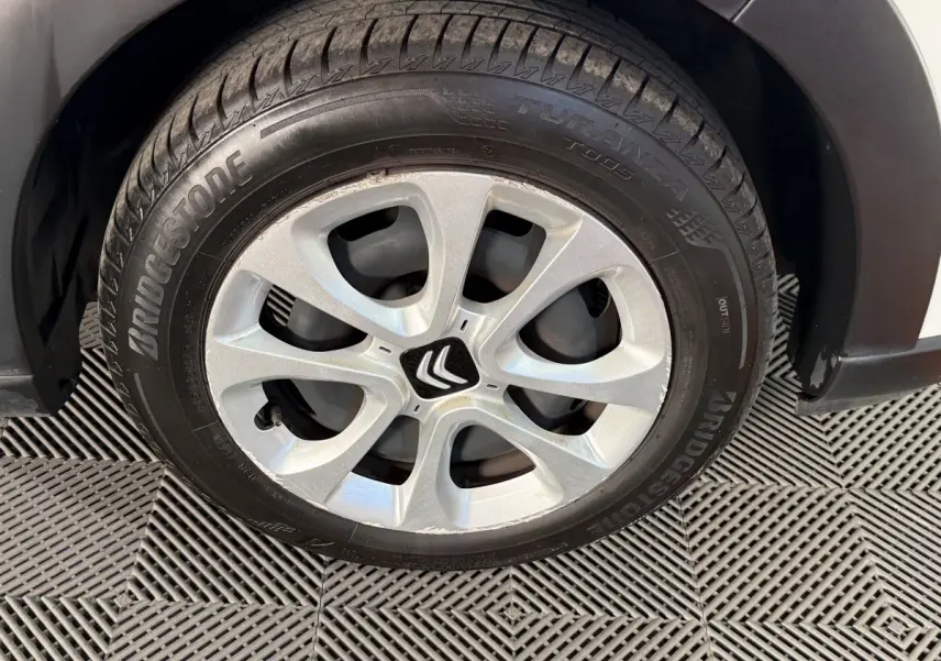 Gros plan sur la roue avant droite de la Citroën C3 blanche, avec jante argentée et pneu Bridgestone.