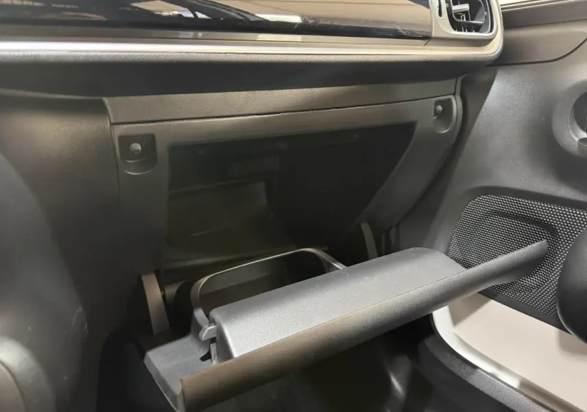 Vue intérieure côté passager de la boîte à gants ouverte dans une Citroën C3 blanche, tableau de bord noir.