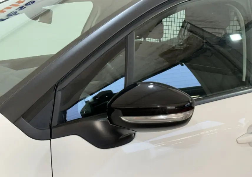 Gros plan sur le rétroviseur noir côté conducteur d’une Citroën C3 blanche, vue latérale gauche.
