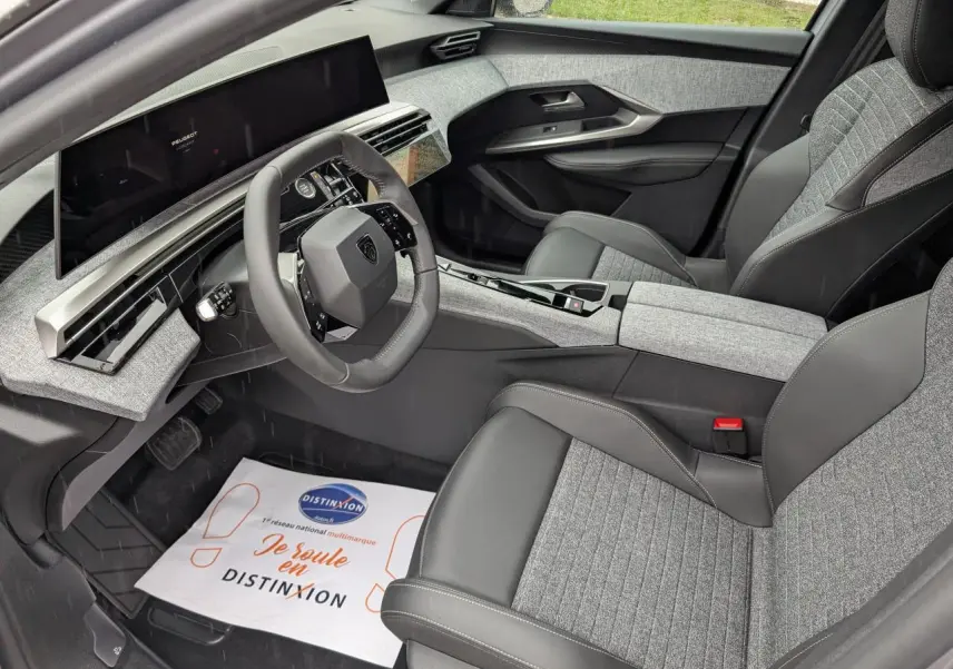 Intérieur avant droit du Peugeot 5008 2025 gris Artense, avec sellerie tissu gris et cuir noir et i-Cockpit panoramique.