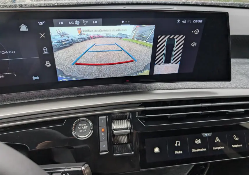 Vue rapprochée du tableau de bord du Peugeot 5008 gris Artense 2025, avec écran de recul et commandes modernes.