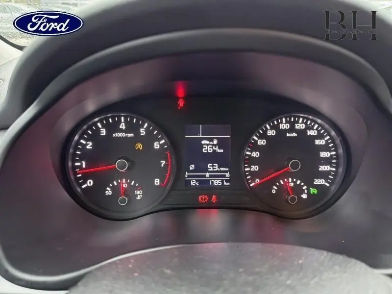 Vue rapprochée du tableau de bord noir d'une KIA Rio 2018, affichant compte-tours, vitesse et écran central numérique.