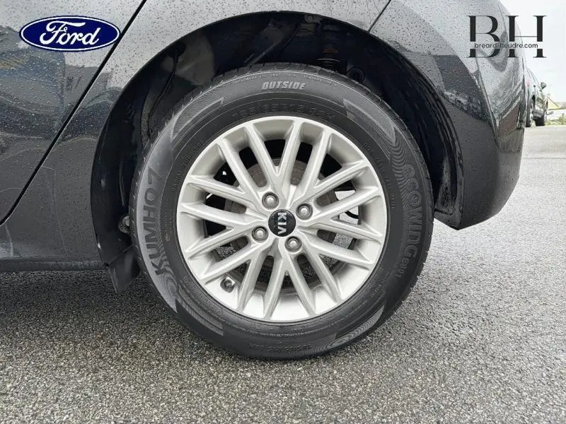 Gros plan sur la roue avant droite avec jante alu argentée d'une KIA Rio noir Ébène 2018.