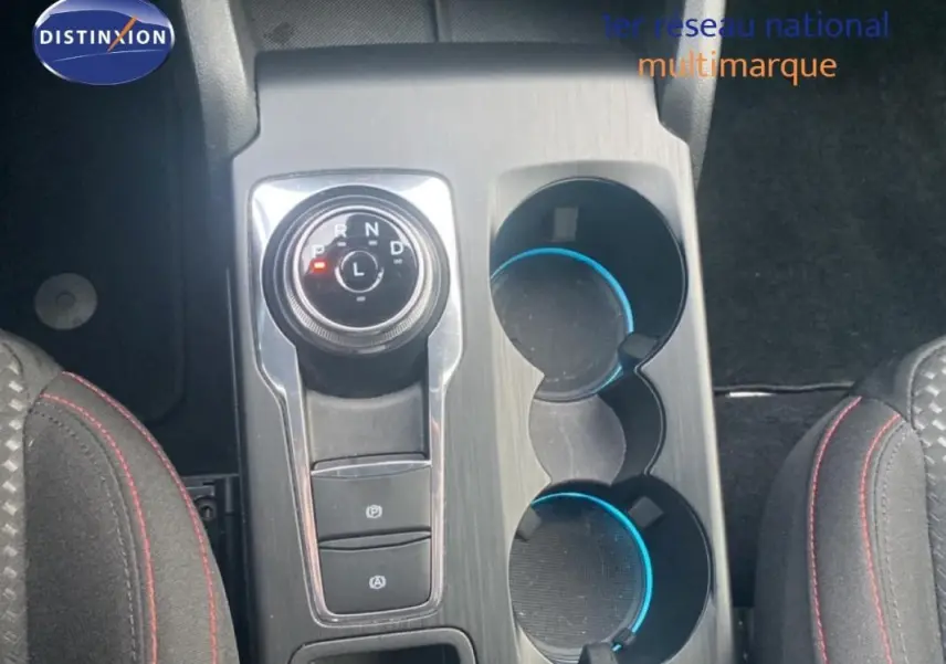 Vue plongeante sur la console centrale grise avec molette de boîte auto et porte-gobelets de la Ford Focus 2024.