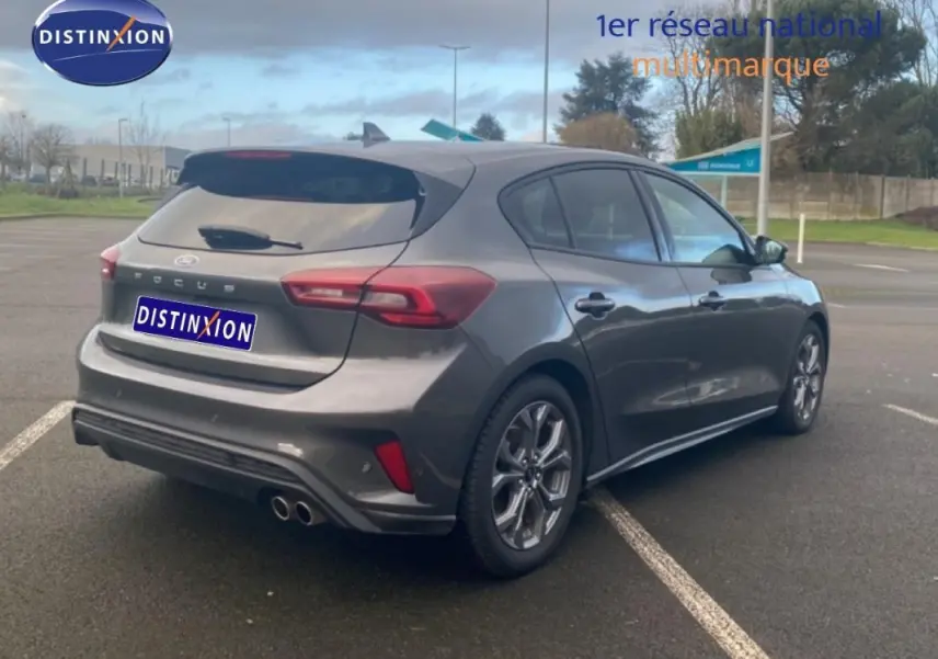 Vue 3/4 arrière droite d'une Ford Focus gris foncé 2024 avec jantes alliage 17 pouces et vitres surteintées.