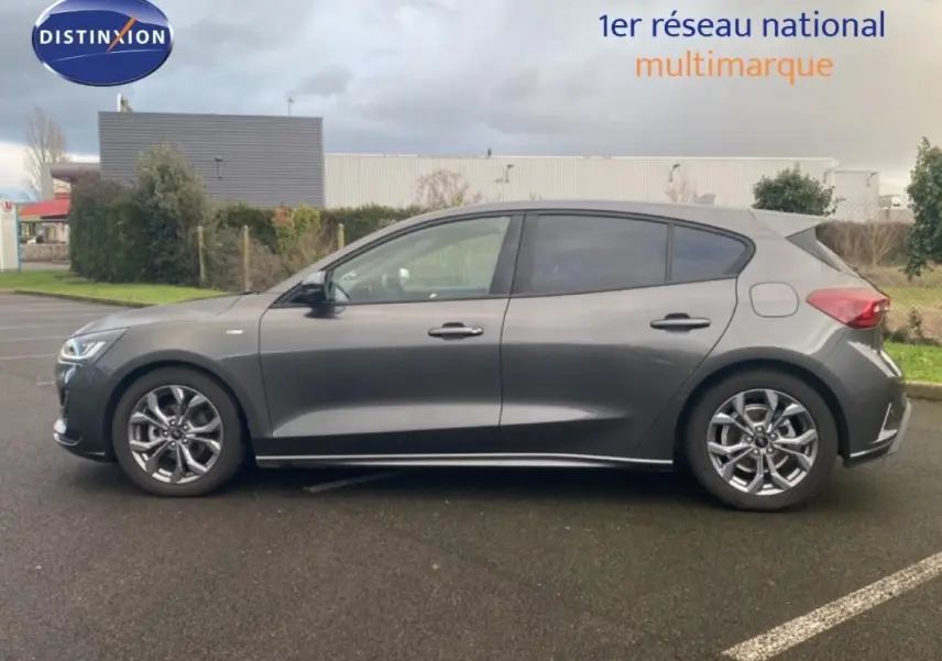 Vue de profil côté gauche d'une Ford Focus gris foncé avec jantes alliage 17 pouces et vitres surteintées.